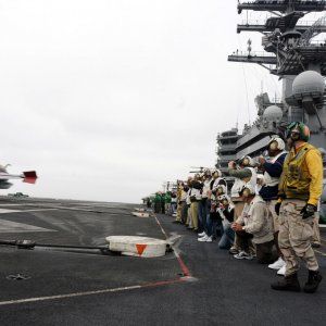 0420-0904-2417-0555_soldiers_gathered_on_the_flight_deck_of_an_aircraft_carrier_as_jets_land_o.jpg