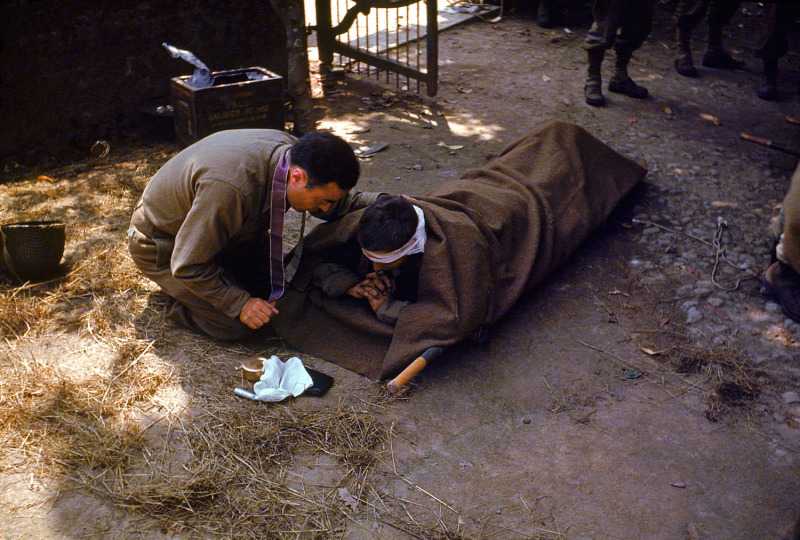 AnAmericanArmychaplainkneelsnexttoawoundedsoldierinordertoadministertheEucharistandLastRitesFrance1944.jpg